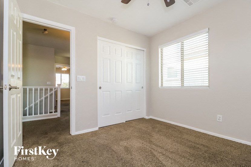 a room with a carpeted floor and a white door and a staircase