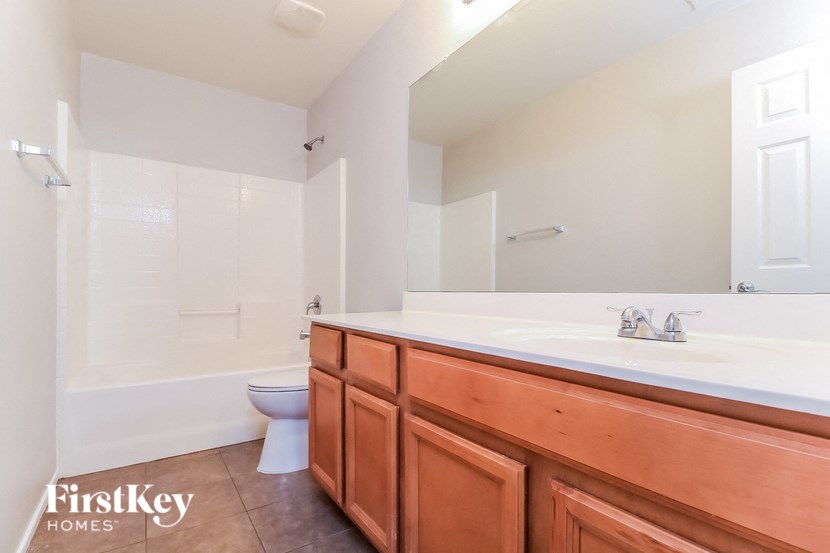 a bathroom with a large mirror and a sink and a toilet