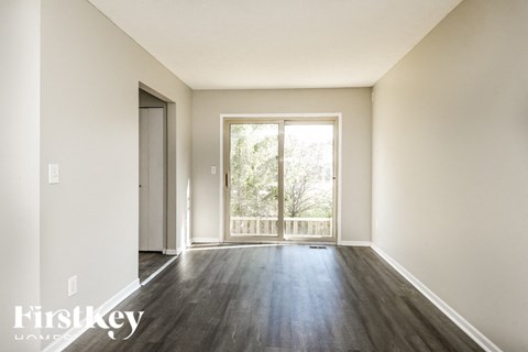 A room with a sliding glass door leading to a balcony.
