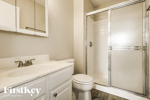 A white bathroom with a glass shower door.