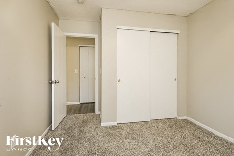 A room with a carpeted floor and a sliding door.