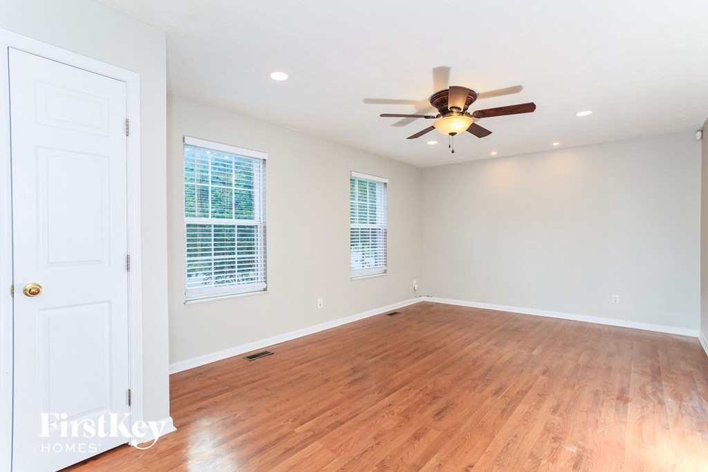 A room with a ceiling fan and wooden flooring.