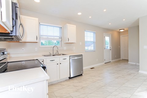 A kitchen with white cabinets and a dishwasher.