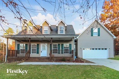 front view of a house with a yard and a blue garage door