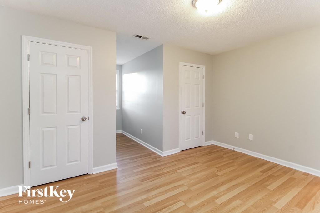 the living room and dining room with wood flooring and two doors