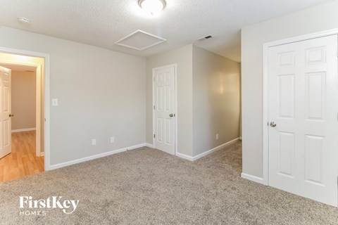 a bedroom with two doors and a carpeted floor