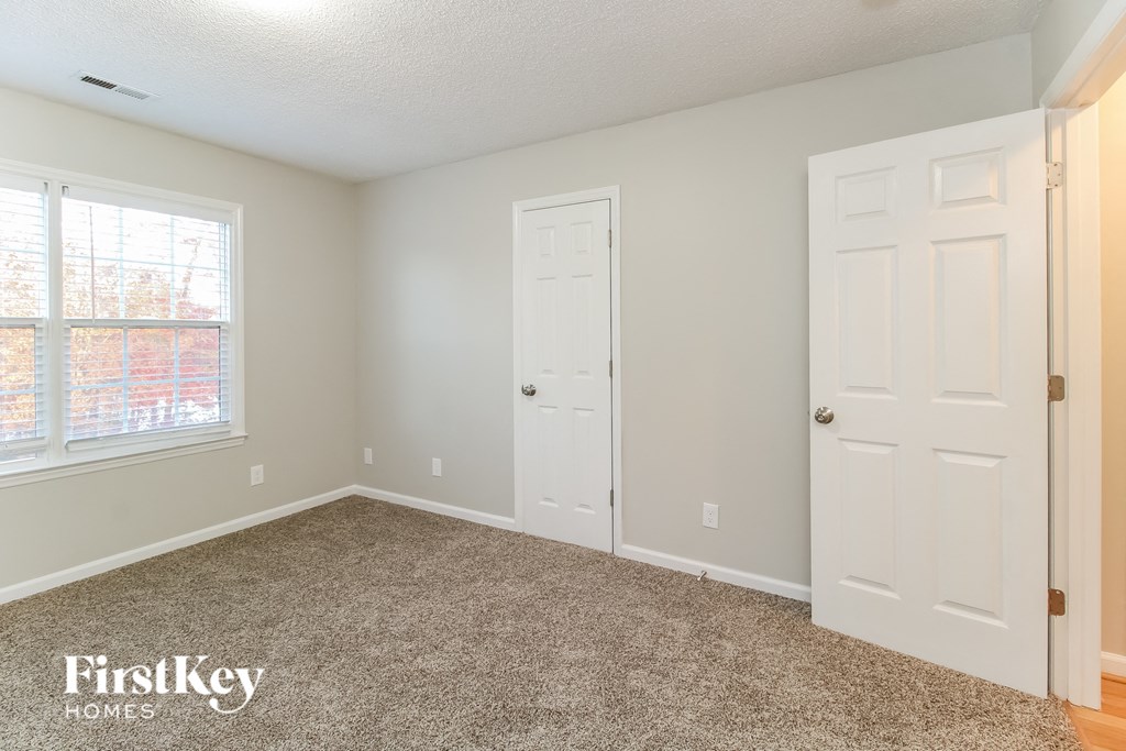 a bedroom with a carpeted floor and two white doors