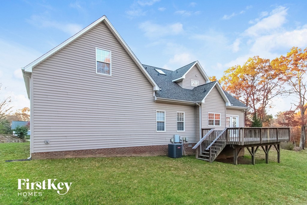 the back of a house with a deck and a yard