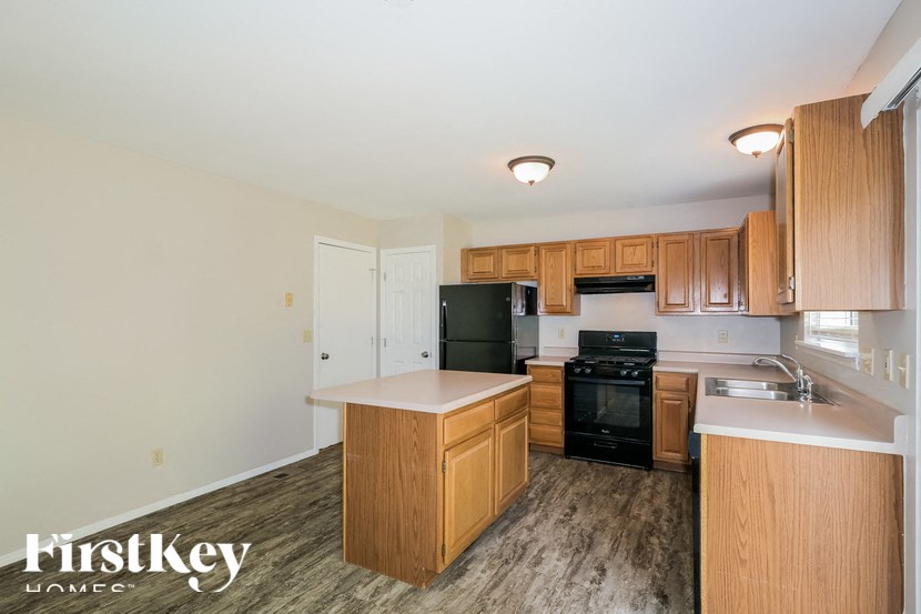 a kitchen with wooden cabinets and a black stove and refrigerator