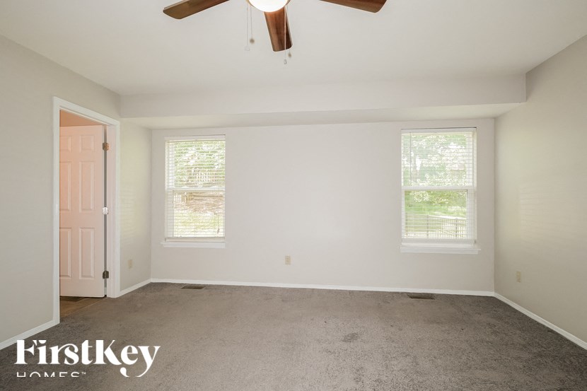 a bedroom with a carpeted floor and a ceiling fan
