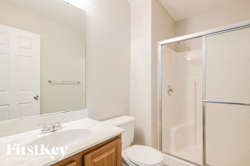 a bathroom with a shower toilet and sink and a mirror