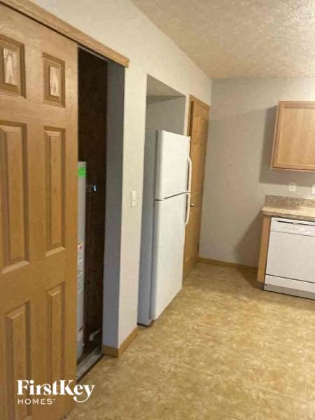 a kitchen with a white refrigerator and a door