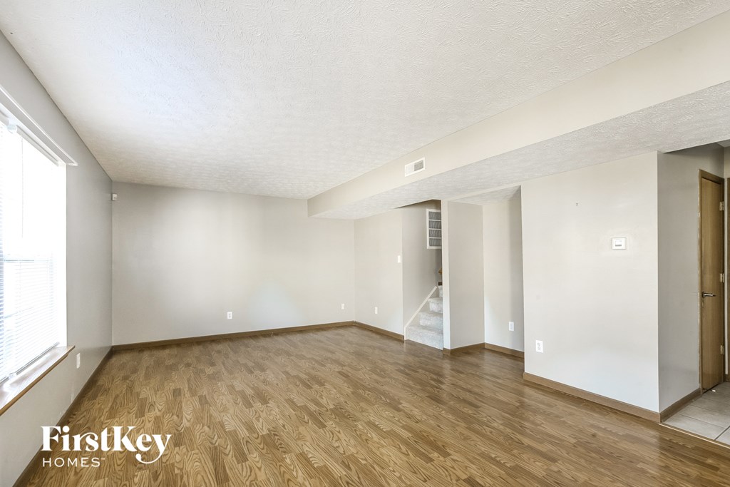 a living room with a hard wood floor and white walls
