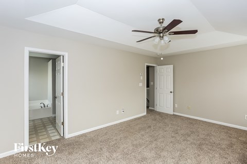 a living room with carpet and a ceiling fan