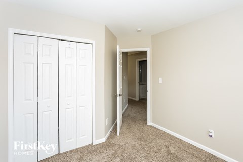 a bedroom with two closets and a hallway to a bathroom