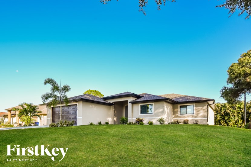 A house with a clear blue sky above it and the words "FirstKey HOME" on the grass.