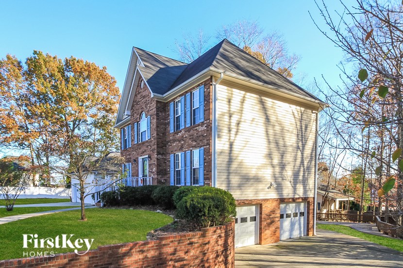 A house with a brick wall and a garage is for sale by FirstKey Homes.