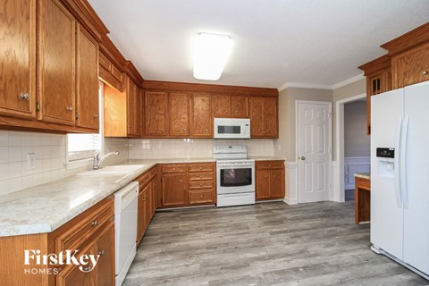 A kitchen with wooden cabinets and a white fridge.