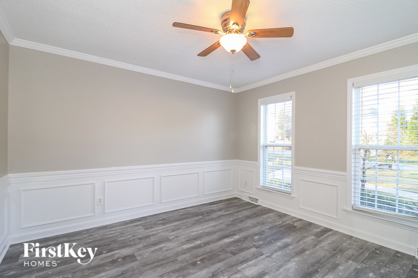 A room with a ceiling fan and wooden flooring.