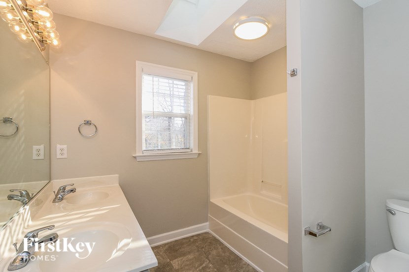 A bathroom with a white sink and a window.