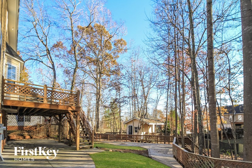A house with a deck and trees in the background.