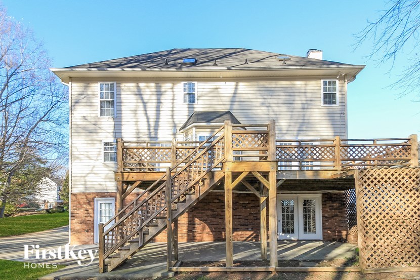 A house with a wooden deck and stairs leading to the front door.