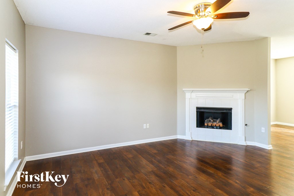 A room with a fireplace and a ceiling fan.