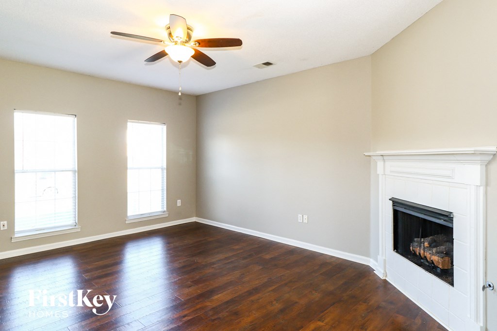 A room with a fireplace and a ceiling fan.