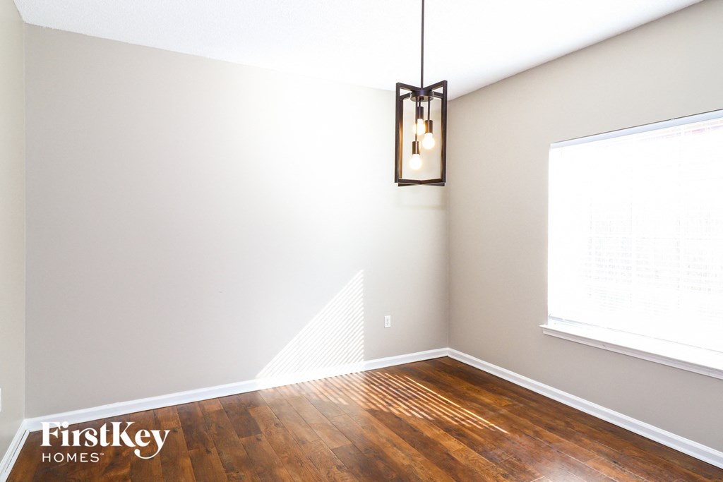 A room with wooden floors and a light hanging from the ceiling.