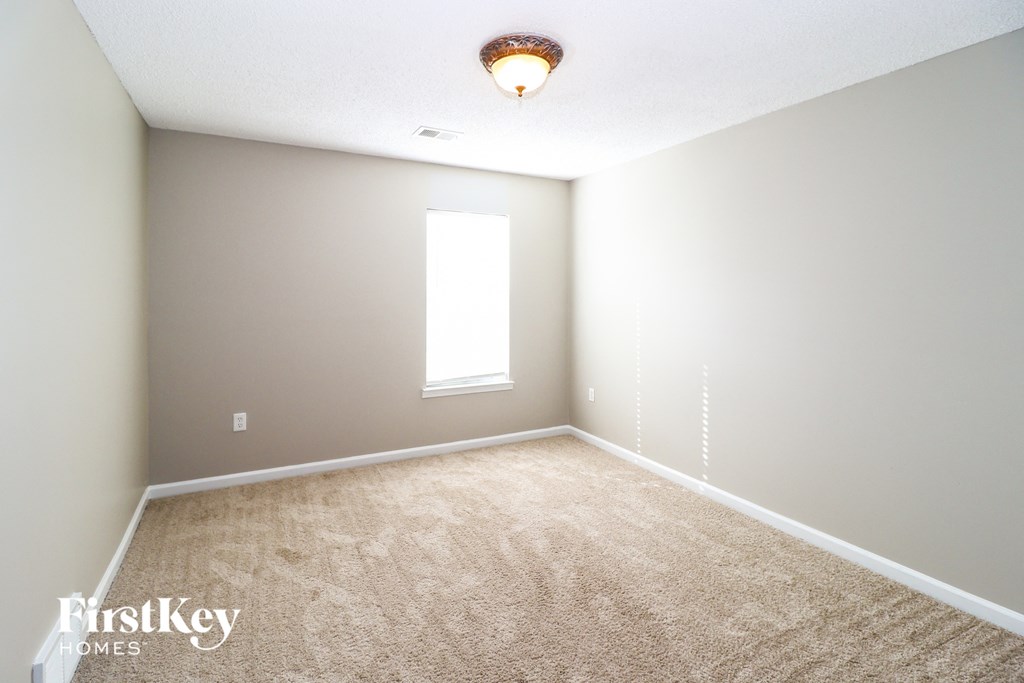 A room with a carpeted floor and a window.