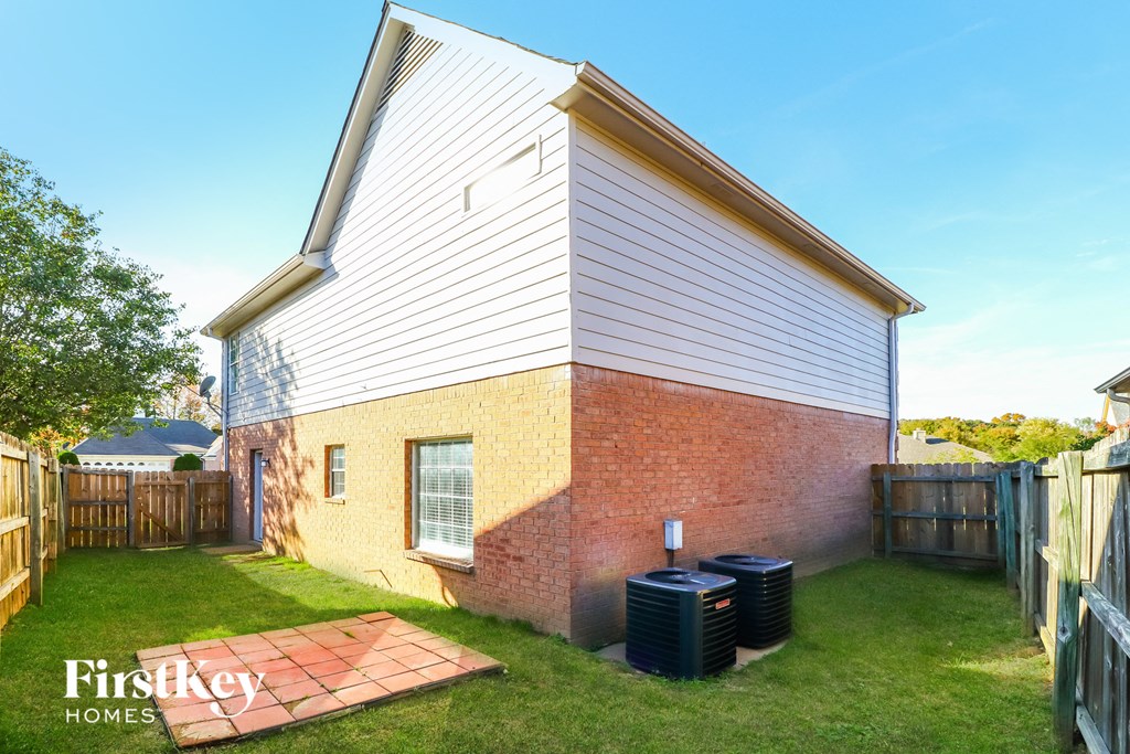 A house with a red brick wall and a wooden fence.