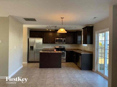 a kitchen with black cabinets and a stainless steel refrigerator