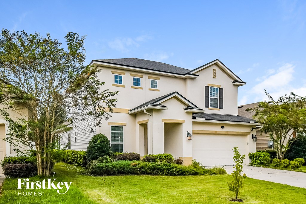 a white house with a lawn and a driveway