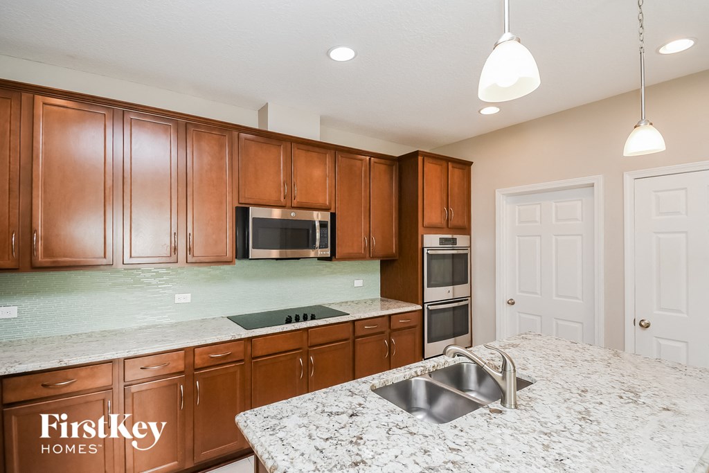 a kitchen with granite counter tops and wooden cabinets