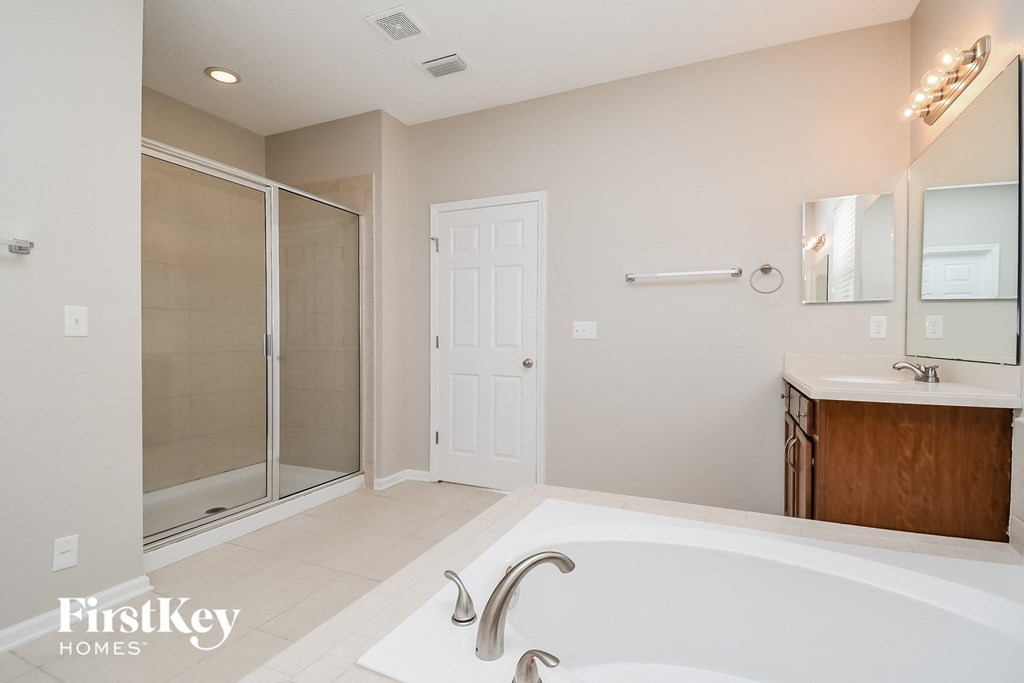 a large white bathroom with a large tub and a shower