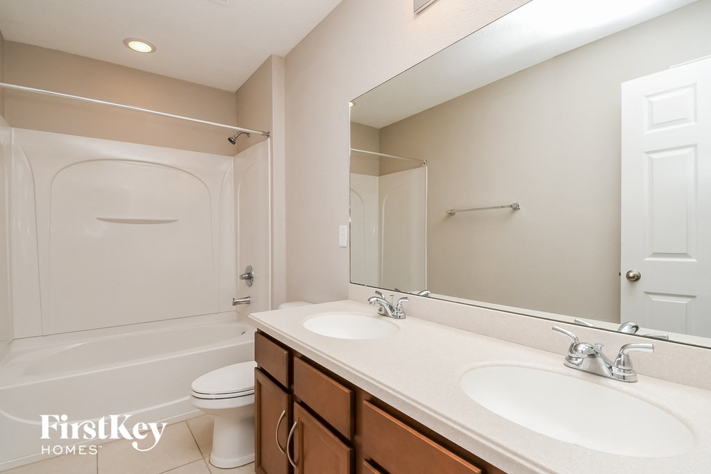 a bathroom with two sinks and a shower and a toilet