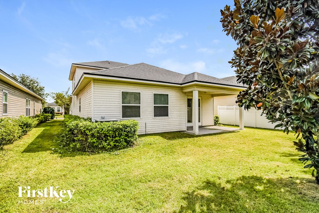a small white house with a yard and a garage