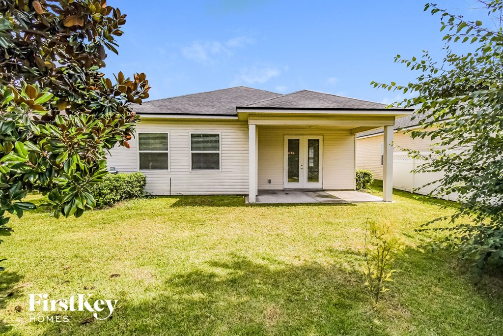 a small white house with a grassy yard and