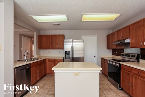 A kitchen with a white island in the middle and wooden cabinets.