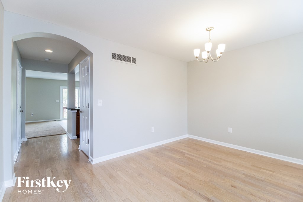 A room with wooden floors and a chandelier.