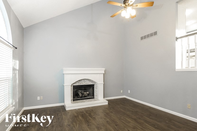 a living room with a fireplace and a ceiling fan