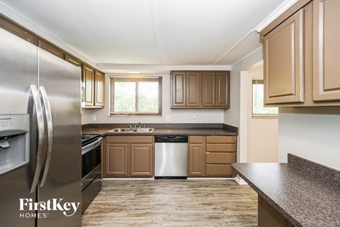 A kitchen with wooden cabinets and a stainless steel refrigerator.