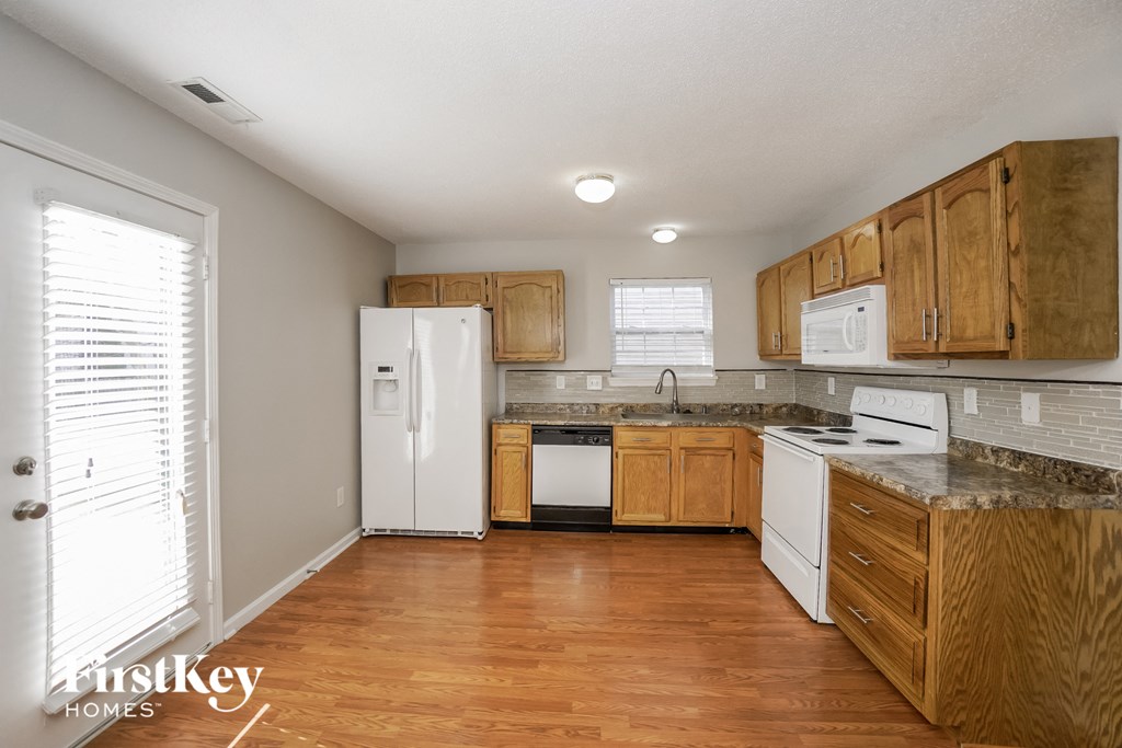 a kitchen with wooden cabinets and white appliances