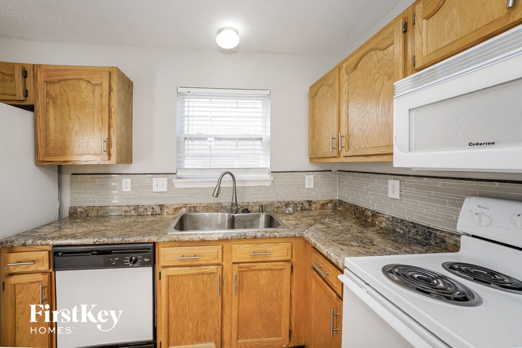 a kitchen with wooden cabinets and white appliances and granite counter tops