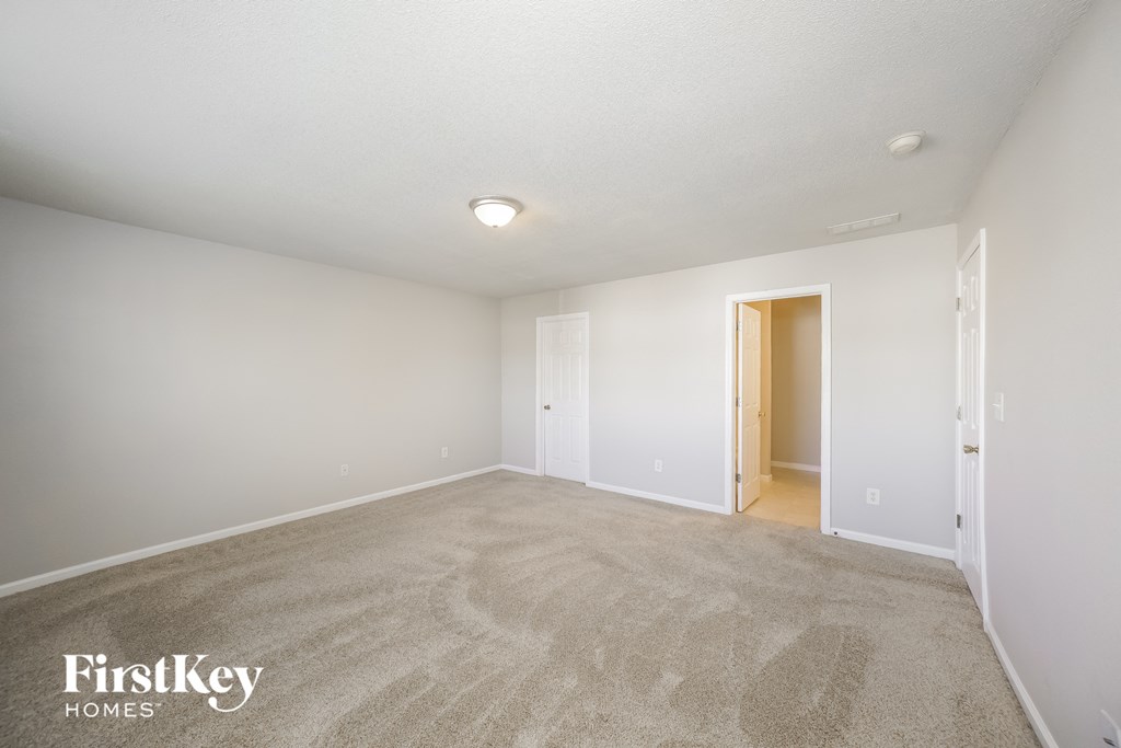 a spacious living room with carpet and white walls