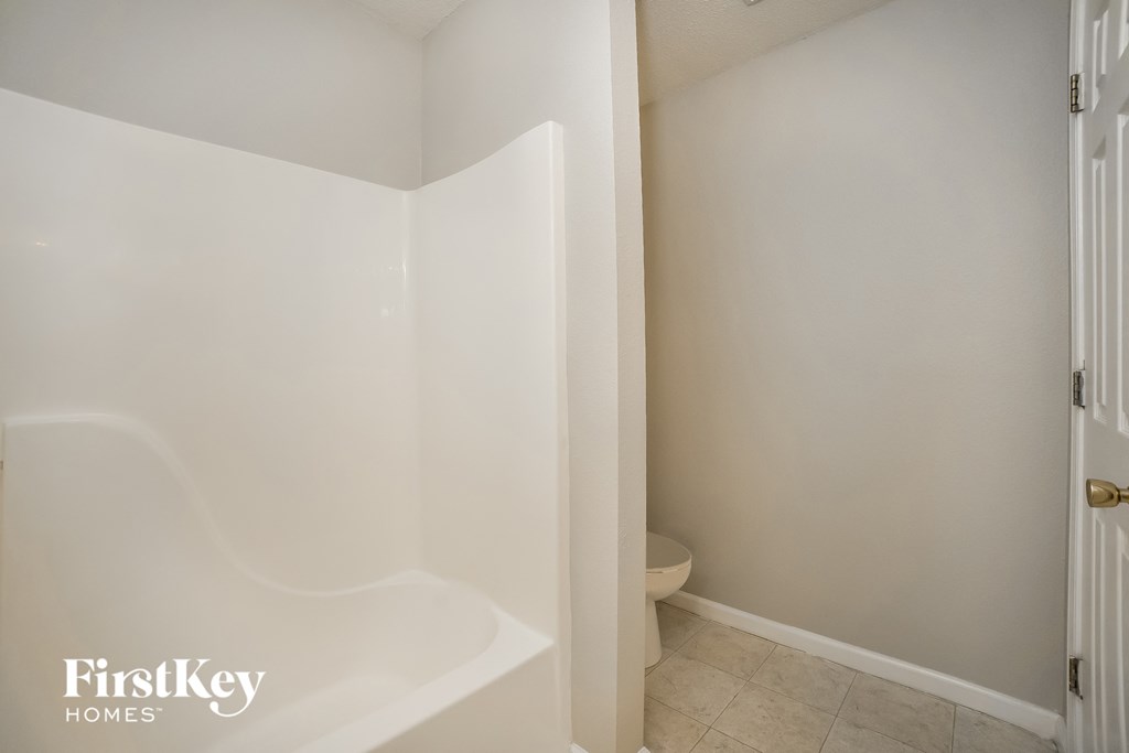 a bathroom with a tub and a toilet in it