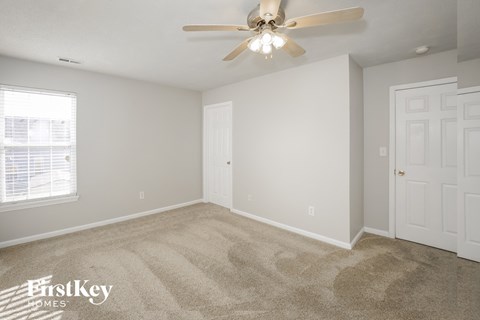 a bedroom with carpet and a ceiling fan