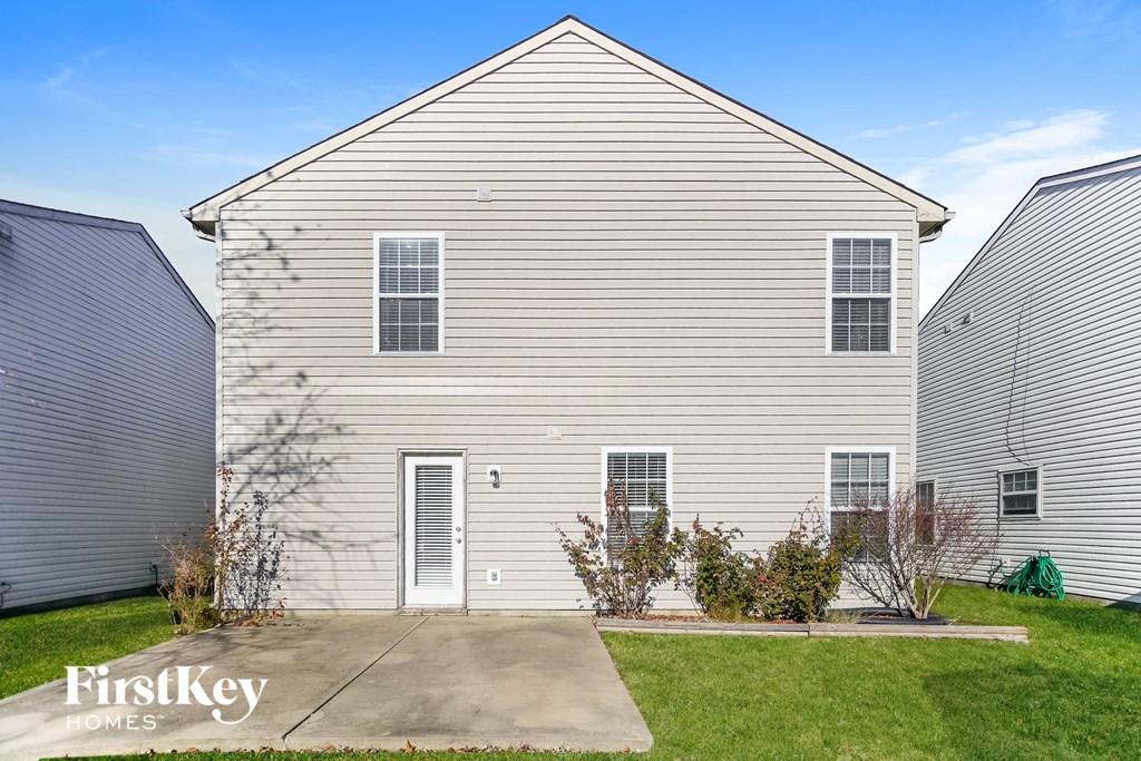 northeast view of a white house with white siding and a driveway