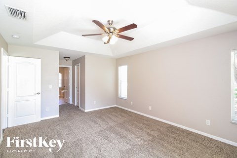a living room with carpet and a ceiling fan