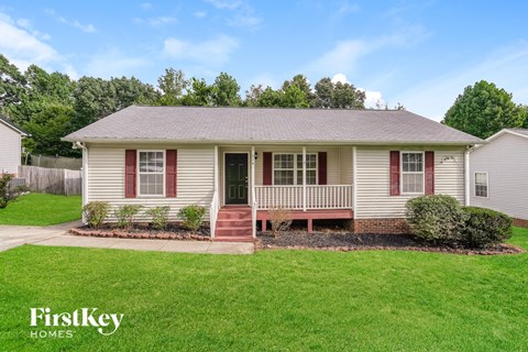 A small house with a red door and a porch.